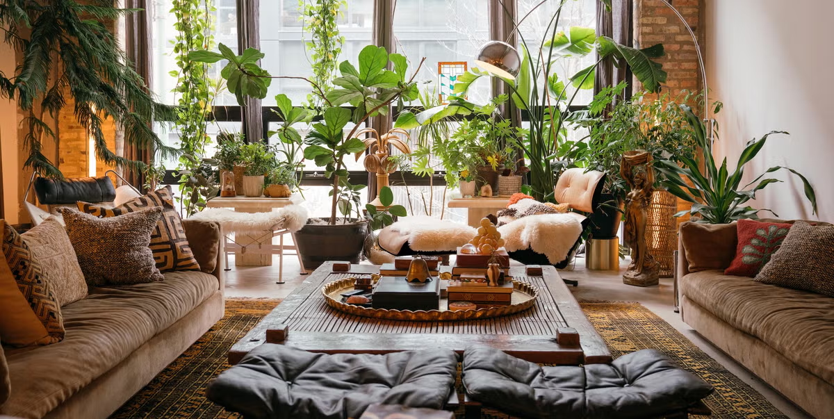 Close-up shot showing various boho textures layered together - a macrame wall hanging, woven basket, velvet cushions, and dried pampas grass